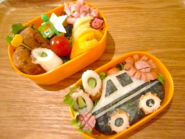 かわいいお弁当を持って笑顔の親子